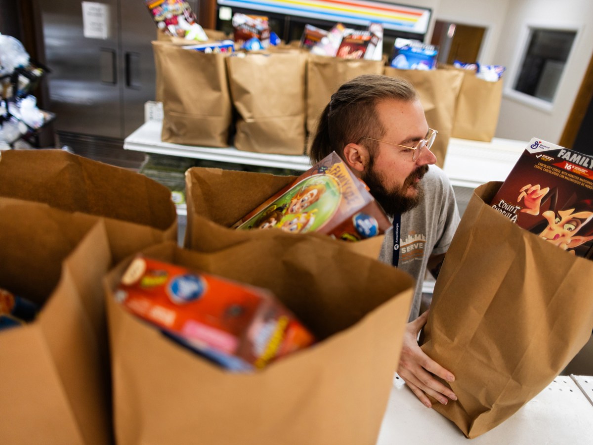 AmeriCorps member Rain Jones, 24, grabs prepared grocery bags to deliver to members of the community supported by the Catholic Charities Archdiocese of Galveston-Houston