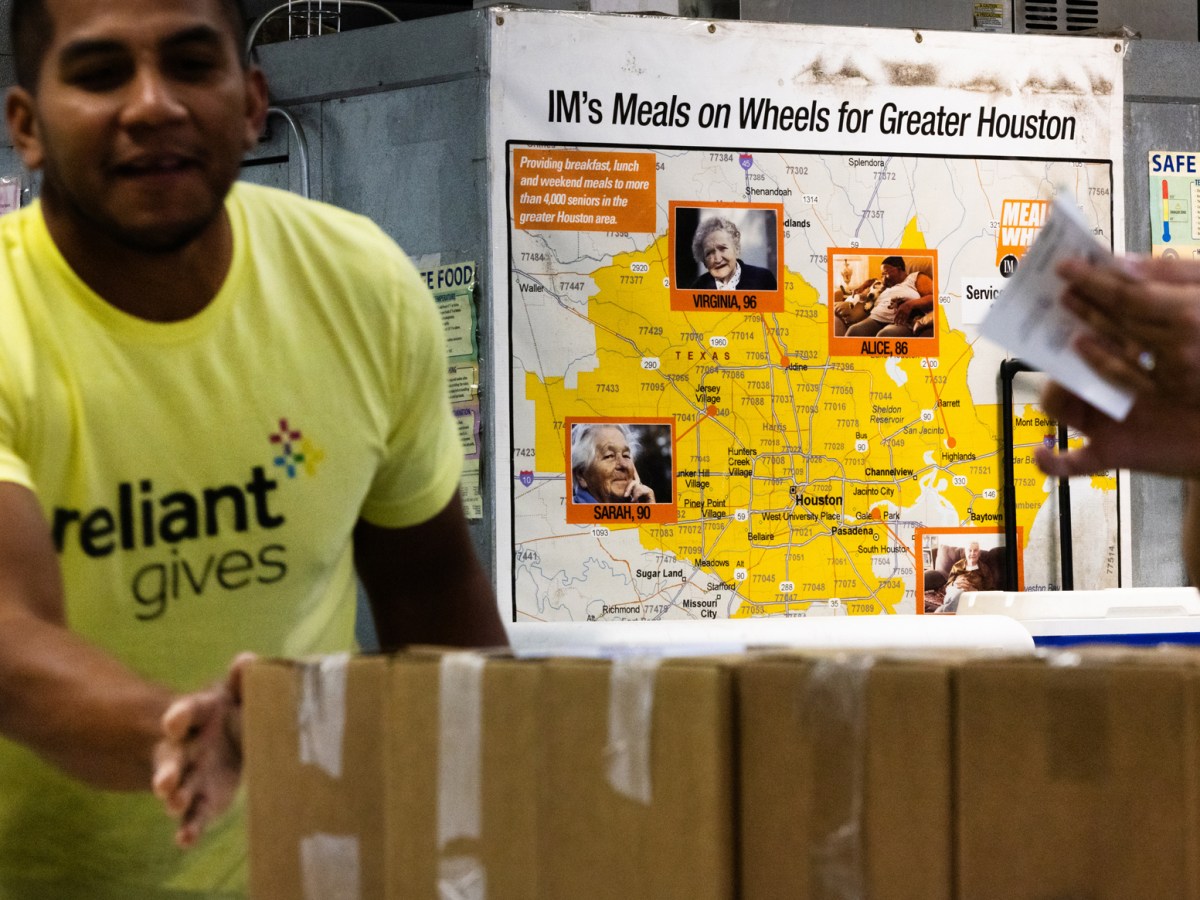 Diego Salazar pushes boxes as he and other Reliant team members support Meals on Wheels by loading meals, Friday, Nov. 17, 2023, in Houston.