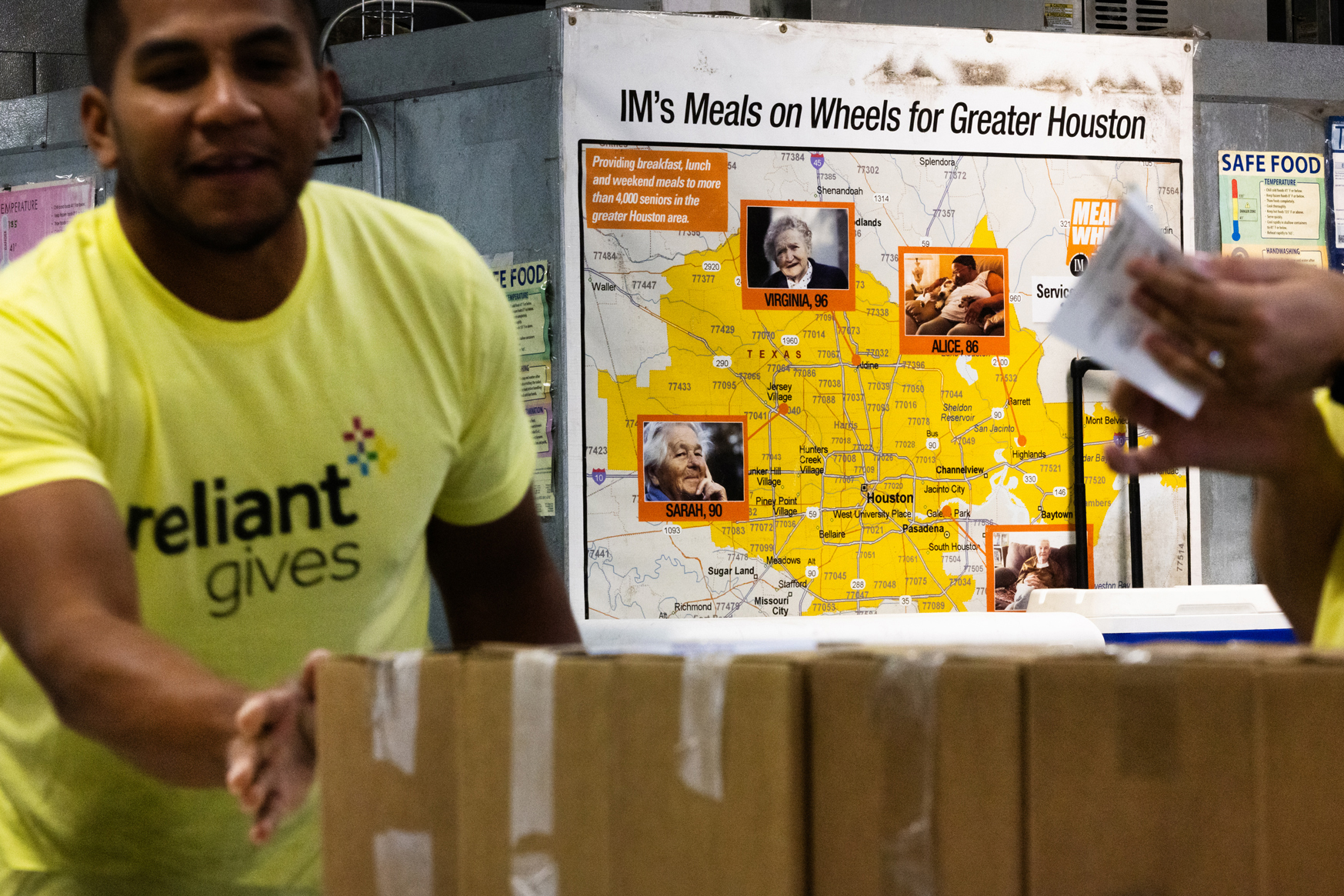 Diego Salazar pushes boxes as he and other Reliant team members support Meals on Wheels by loading meals, Friday, Nov. 17, 2023, in Houston.