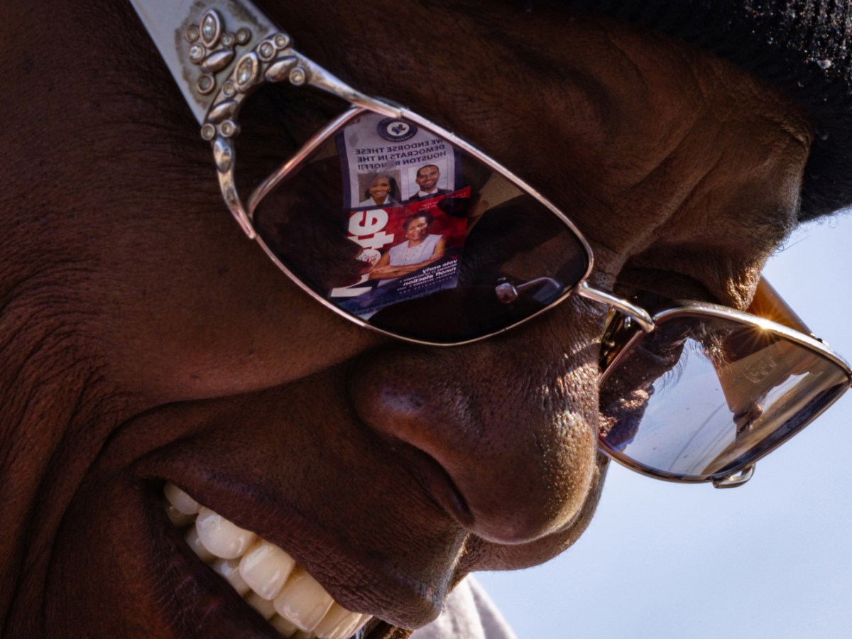 Congresswoman Sheila Jackson Lee’s photo is visible on the glasses of her supporter and campaign worker Fafaye Nickson during early voting of a Houston mayoral run-off race.
