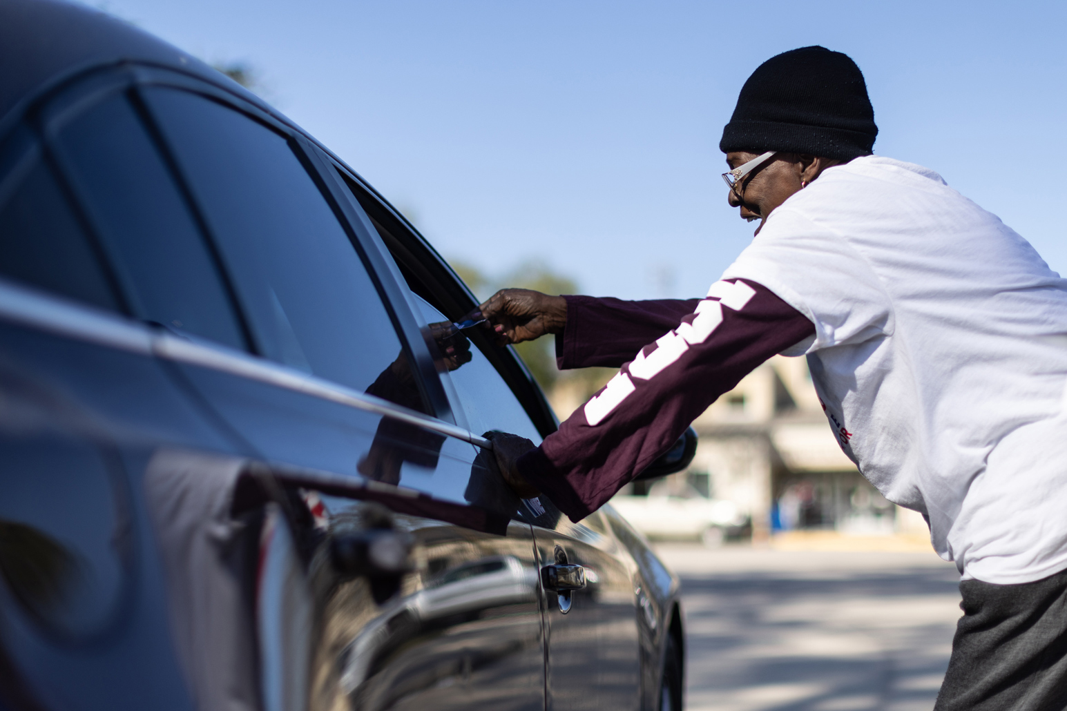 Candidate supporter and campaign worker shares promotional flyers to incoming voters near a polling place in Houston.