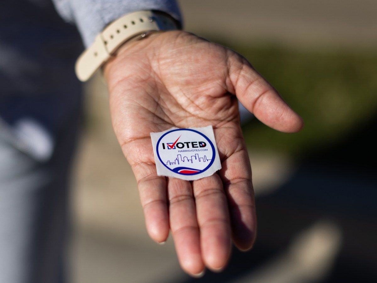 Voter holds a "I Voted" sticker during early voting.