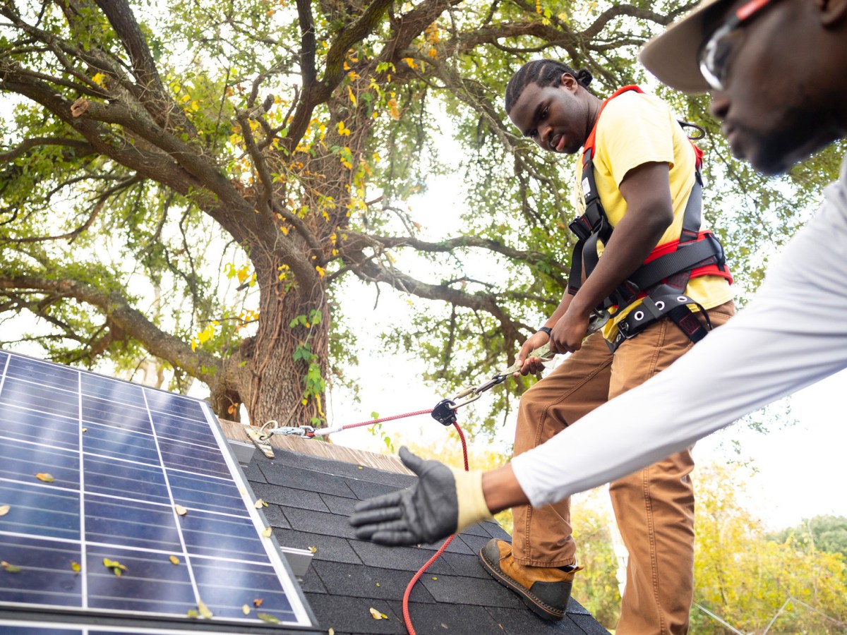 Charlie Smith practices harnessing into a roof during solar panel installation training hosted by South Union Community Development Corporation