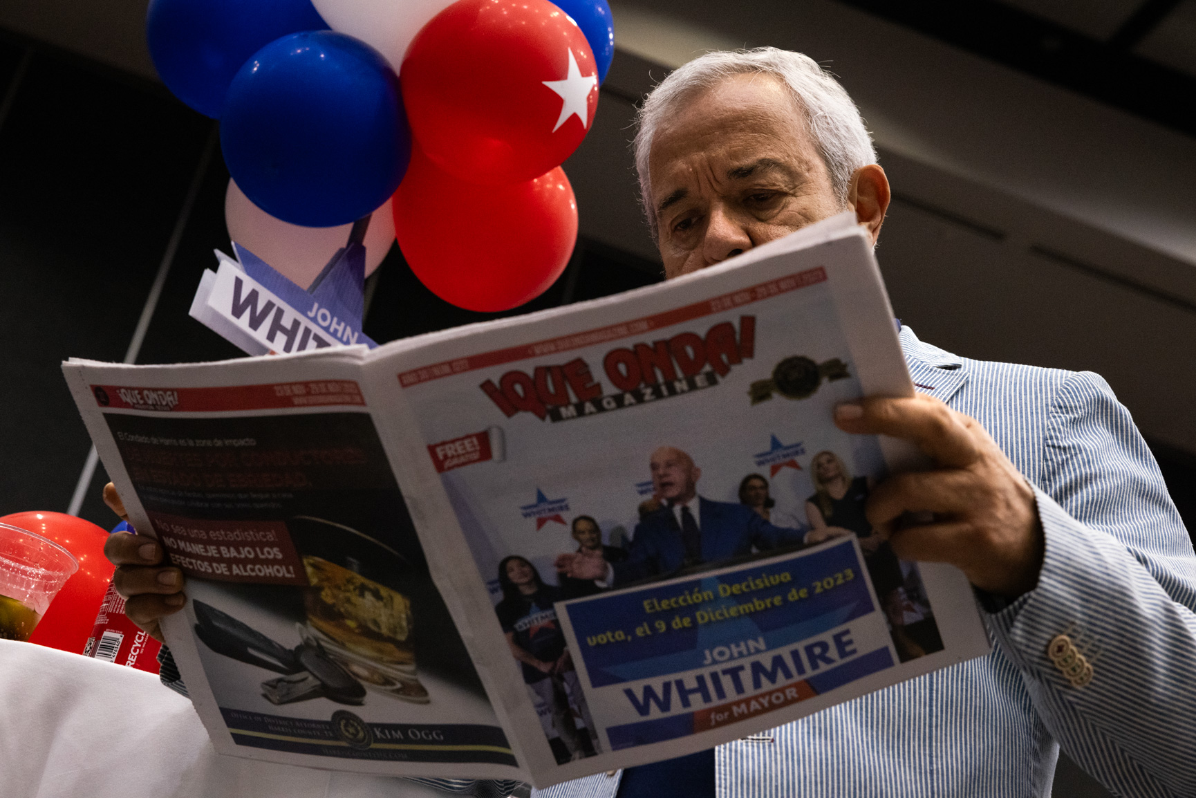 Rafael Gomez reads a copy of ¡Que Onda Magazine! with a cover photo of state Sen. John Whitmire during a watch party at the George R. Brown Convention Center, Saturday, Dec. 9, 2023, in Houston. (