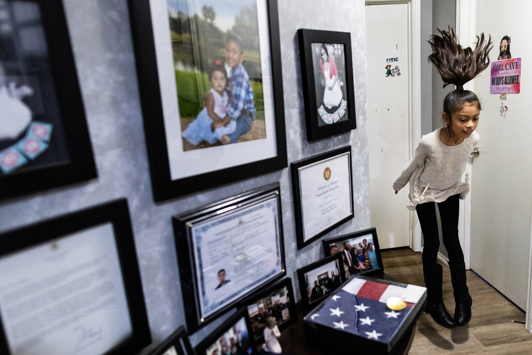 Carmen Escobar, 9, leaps outside of her bedroom on Tuesday, Jan. 9, 2024, in Pearland. A tribute dedicated to the family effort's to bring home Carmen's father, Jose Escobar, after he was deported to El Salvador in 2017, is the centerpiece on the second floor of the family's home.