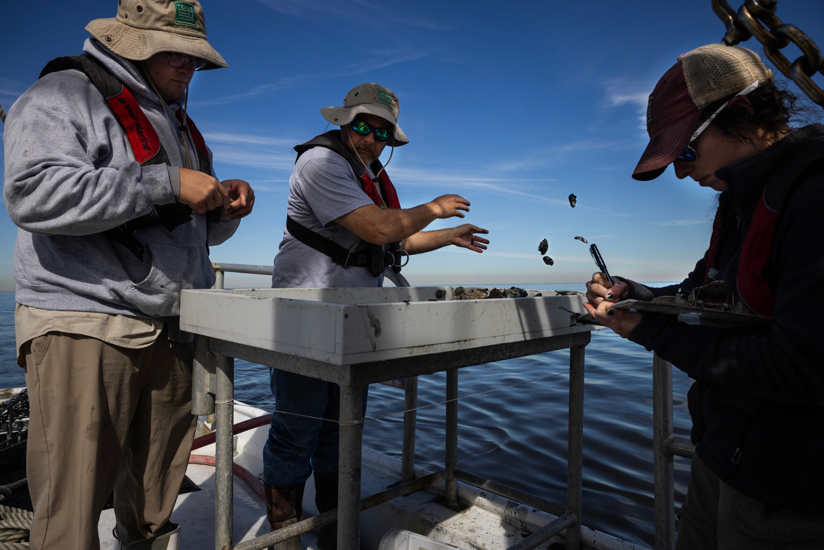 From left, Jason Williams, technician, Mark Krupp, technician, and Jessica Geiskopf, biologist, of Texas Parks and Wildlife, survey an oyster harvesting area Tuesday in Seabrook.