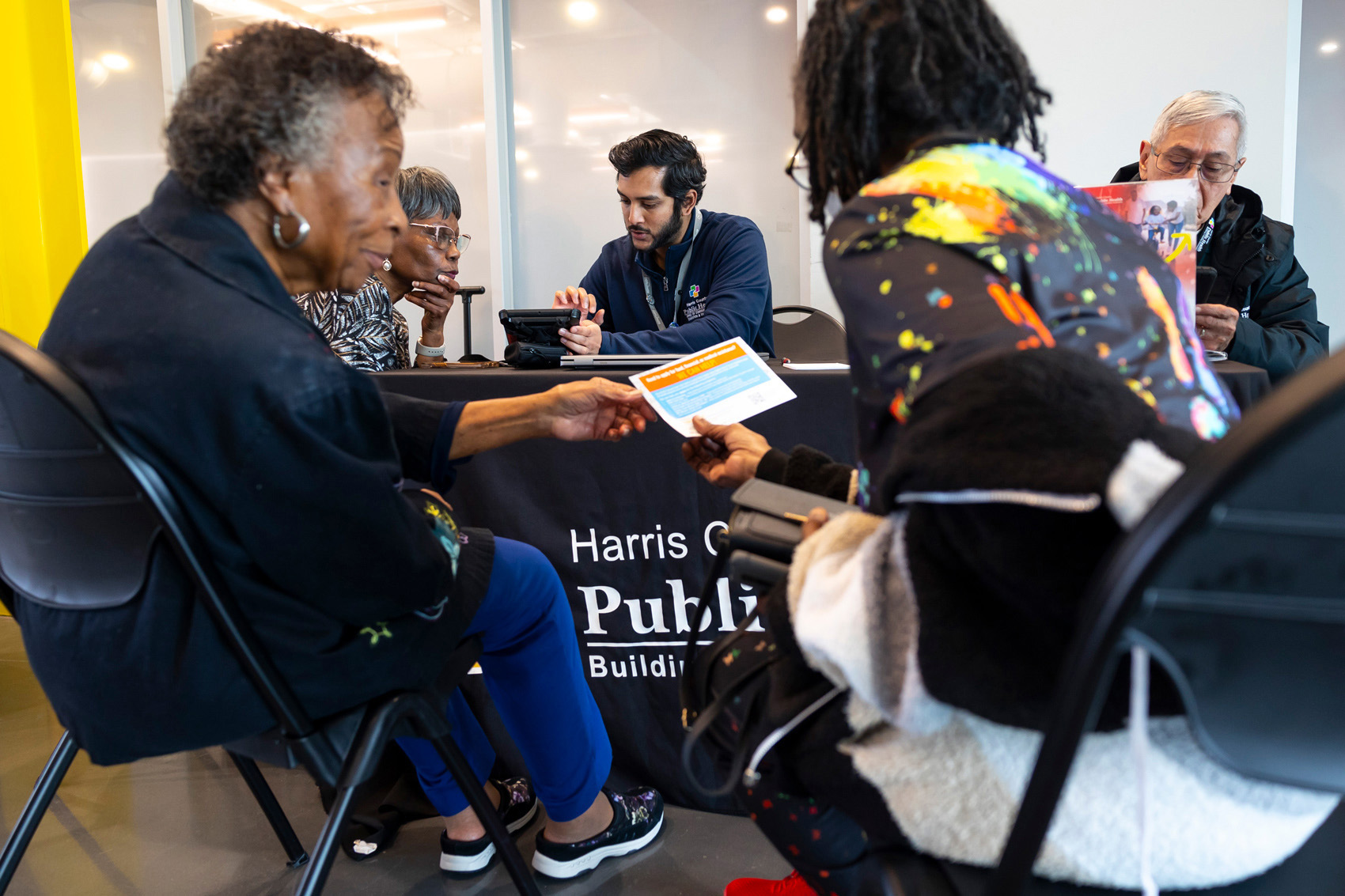 Applicants surround Harris County Public Health employees as they fill out the application forms for Uplift Harris, a guaranteed income pilot at the Sunnyside Multi-Service Center on Thursday, Feb. 01, 2024, in Houston.