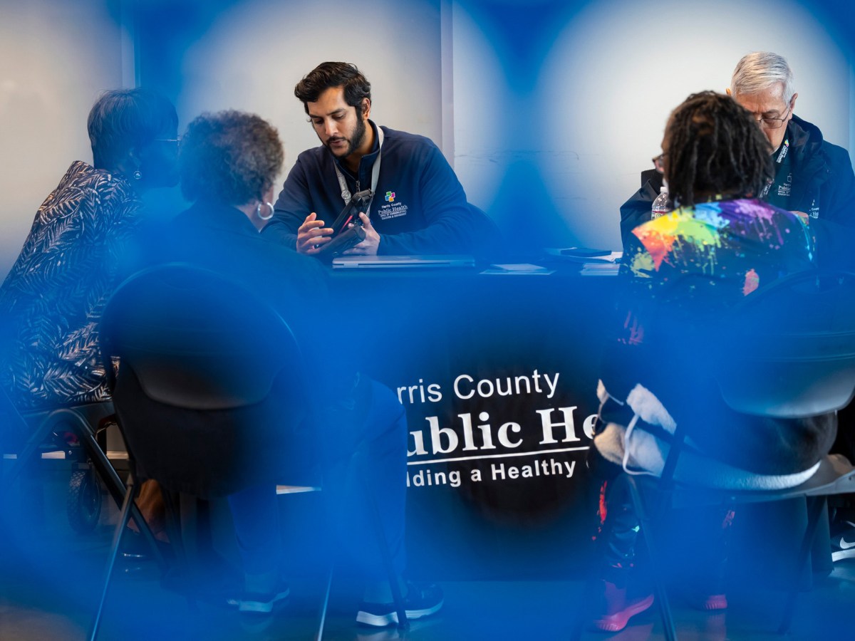 Justin Rahman, outreach program manager for Harris County Public Health, speaks with an applicant about Uplift Harris, a guaranteed income pilot program at the Sunnyside Multi-Service Center