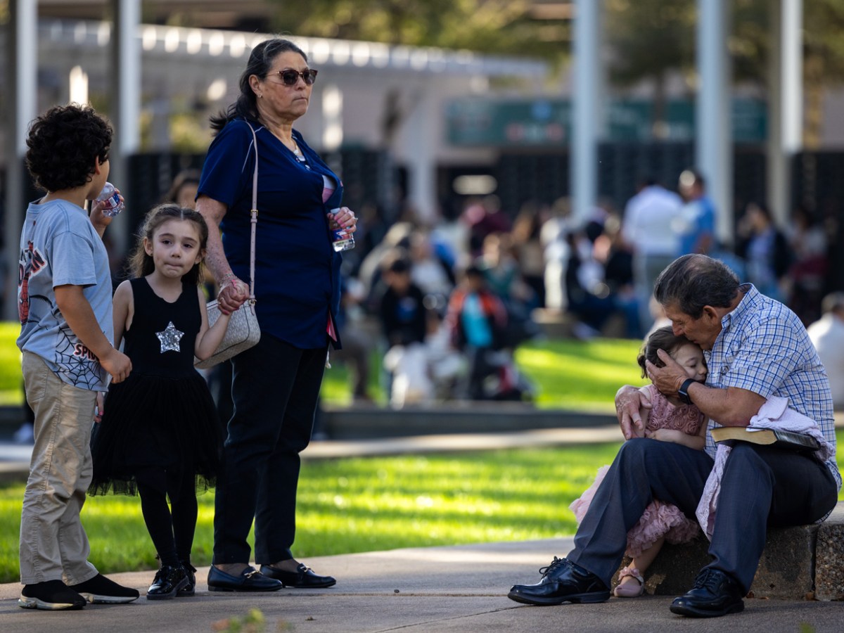 A family sits at a family reunification area outside Lifetime Fitness after a reported shooting at Lakewood Church, Sunday, Feb. 11, 2024, in Houston