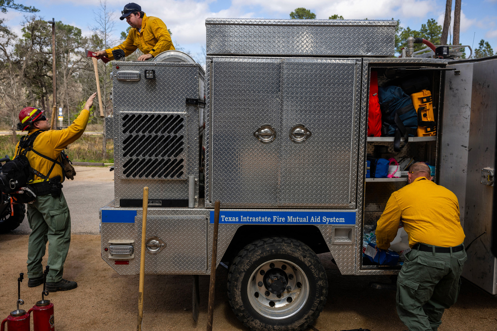 Firefighters put on their gear and assemble equipment before a controlled burn of a section of the Houston Arboretum & Nature Center