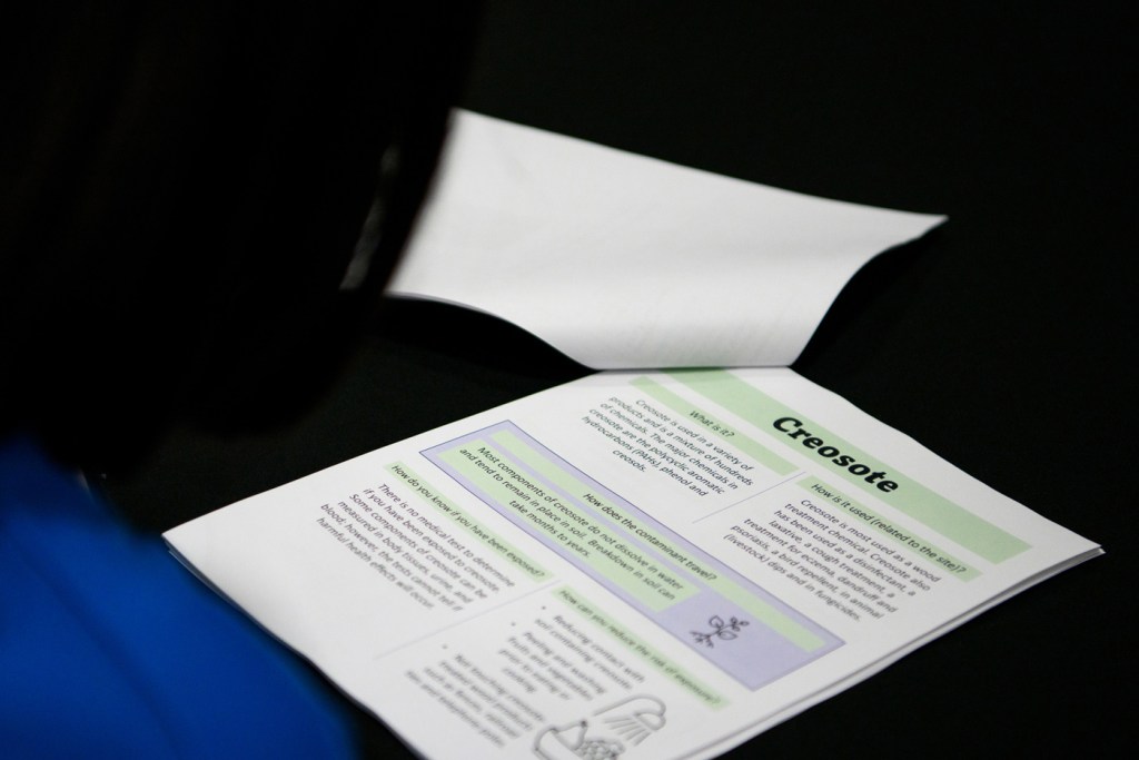 An attendee reads a distributed packet as the EPA hosts a meeting to update Fifth Ward residents on Union Pacific testing and contamination on Thursday