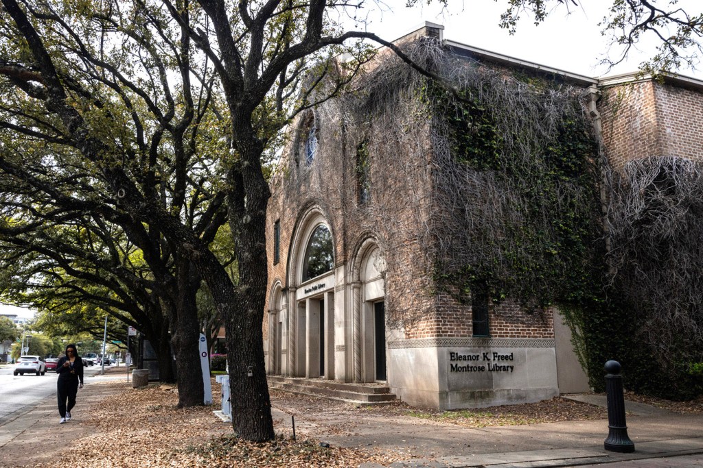 A woman walks past the Freed-Montrose Neighborhood Library, Thursday, March 7, 2024, in Houston.