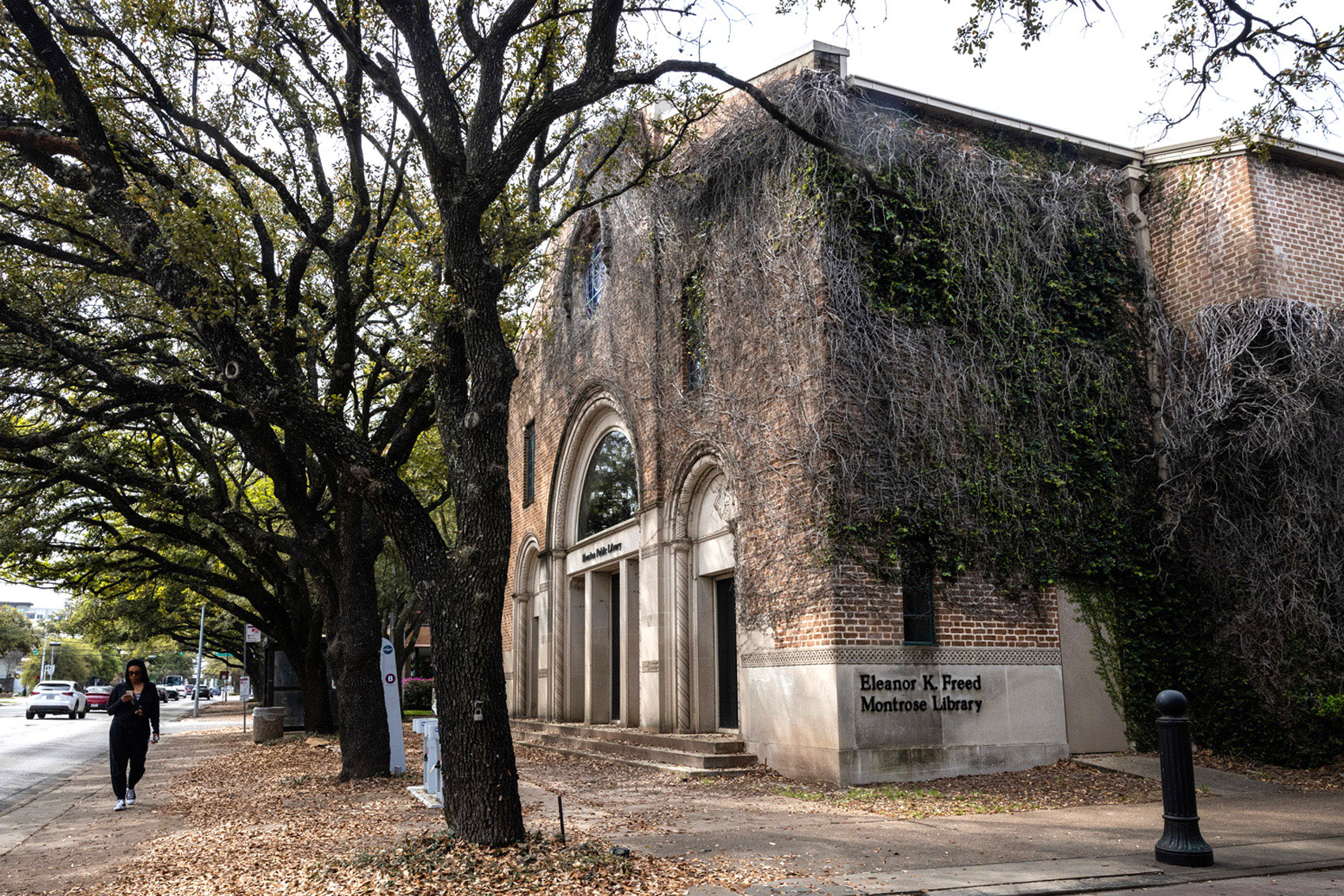 A woman walks past the Freed-Montrose Neighborhood Library, Thursday, March 7, 2024, in Houston.