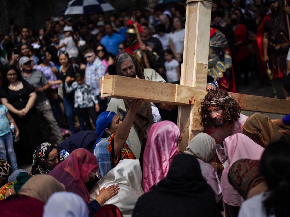 Jesus Christ, played by Marcos Gonzalez, is surrounded by people playing his followers while carrying his cross during the Stations of the Cross on Good Friday at Queen of Peace Catholic Church, Friday, March 29, 2024, in Houston.