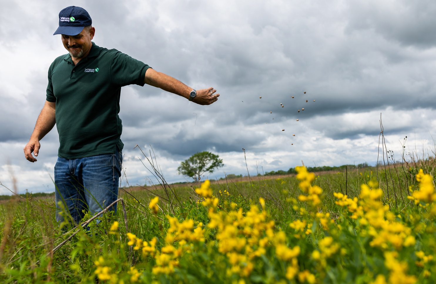 The Nature Conservancy coastal grasslands steward Calan Coleman, 38, throws seeds on the Nash Prairie during a tour of the 427-acre coastal prairie about 70 miles southwest of Houston