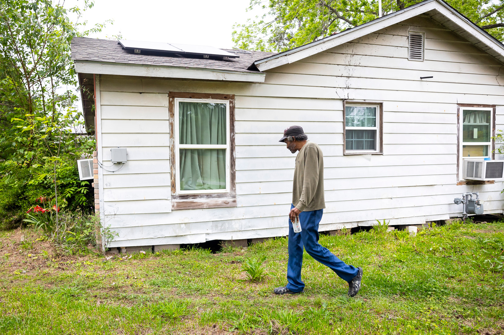 Mal Berth walks around his house to point out water issues on Monday, April 15, 2024, in Houston. 