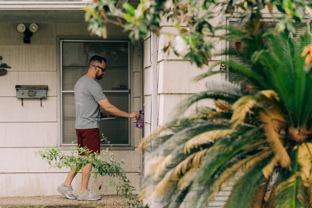 Kyle Scott, conservative candidate running for At-Large Place 2 on the Harris County Appraisal District board, drops off a campaign flyer during a blockwalk to encourage people to vote in Spring Branch