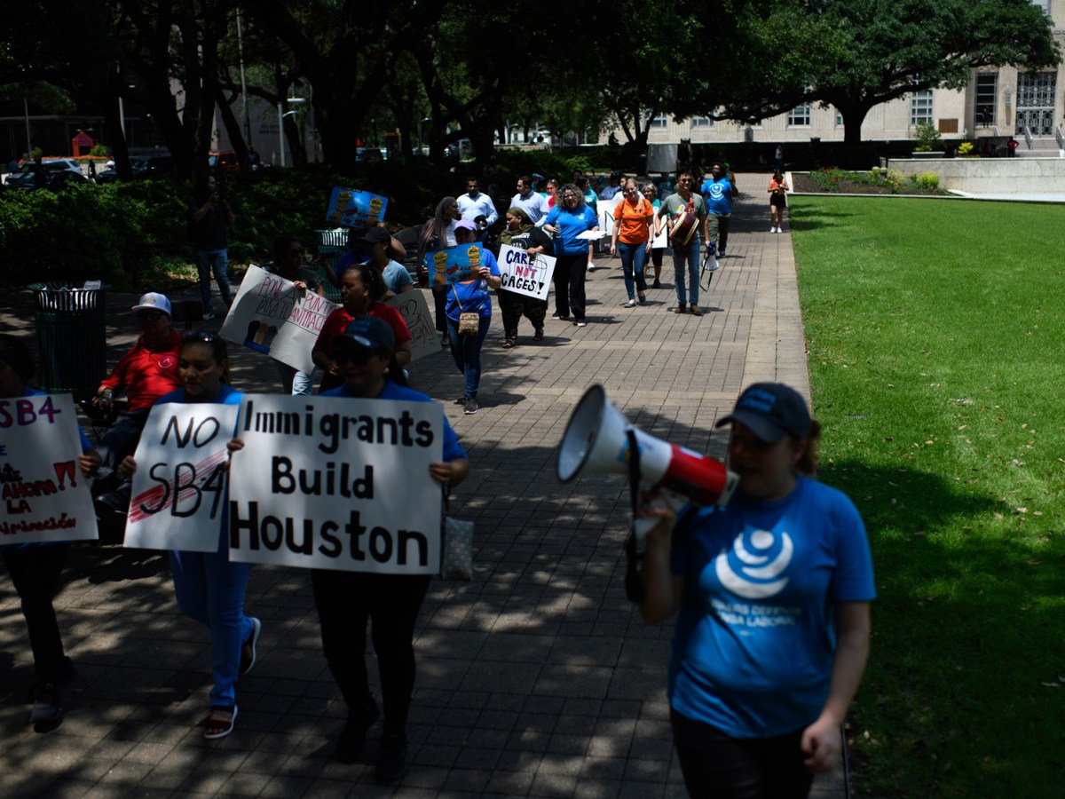 Immigrant rights activists march around City Hall during a rally on Tuesday