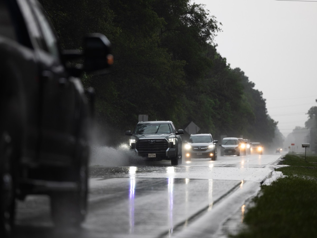 Cars drive through flooded roads