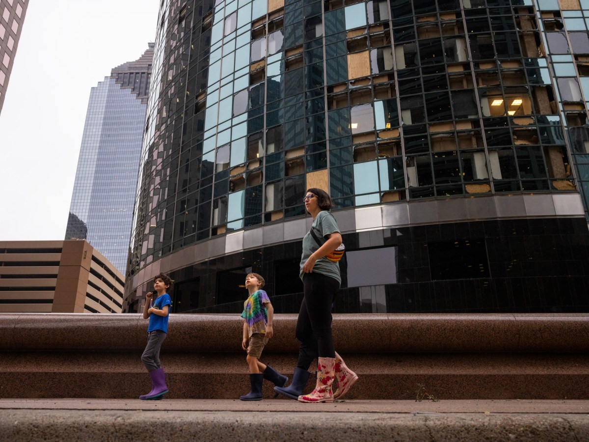 The Muncy family looks at damaged buildings in downtown after a storm broke windows in many of the skyscrapers on Louisiana Street, Friday, May 17, 2024, in Houston.