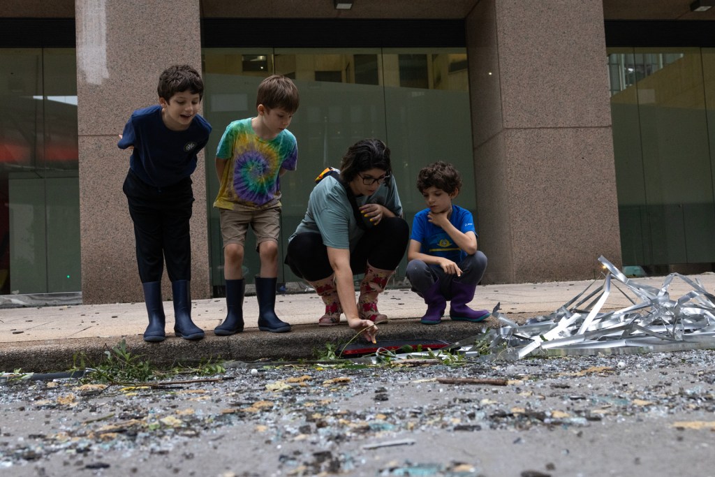 From left, Luke, 8, Ryan, 6, Jaqueline, and Tanner Muncy, 6, look at the damage and debris on Louisiana Street the morning after a storm in downtown, Friday, May 17, 2024, in Houston.