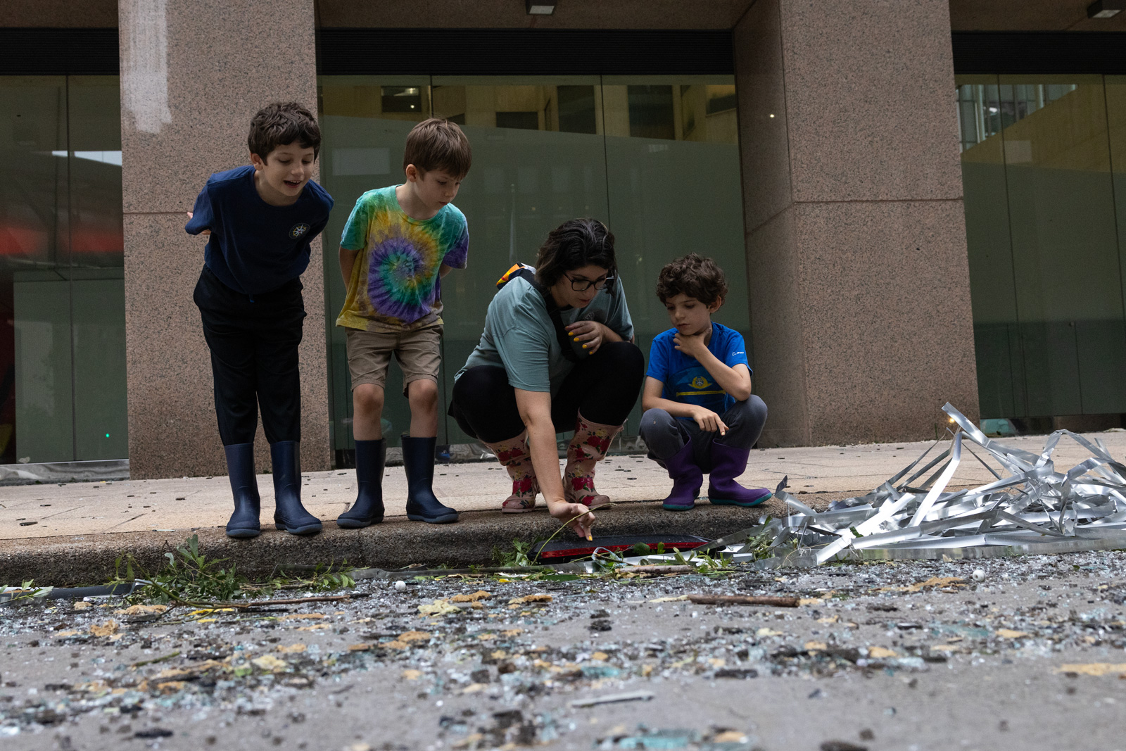 From left, Luke, 8, Ryan, 6, Jaqueline, and Tanner Muncy, 6, look at the damage and debris on Louisiana Street the morning after a storm in downtown, Friday, May 17, 2024, in Houston.