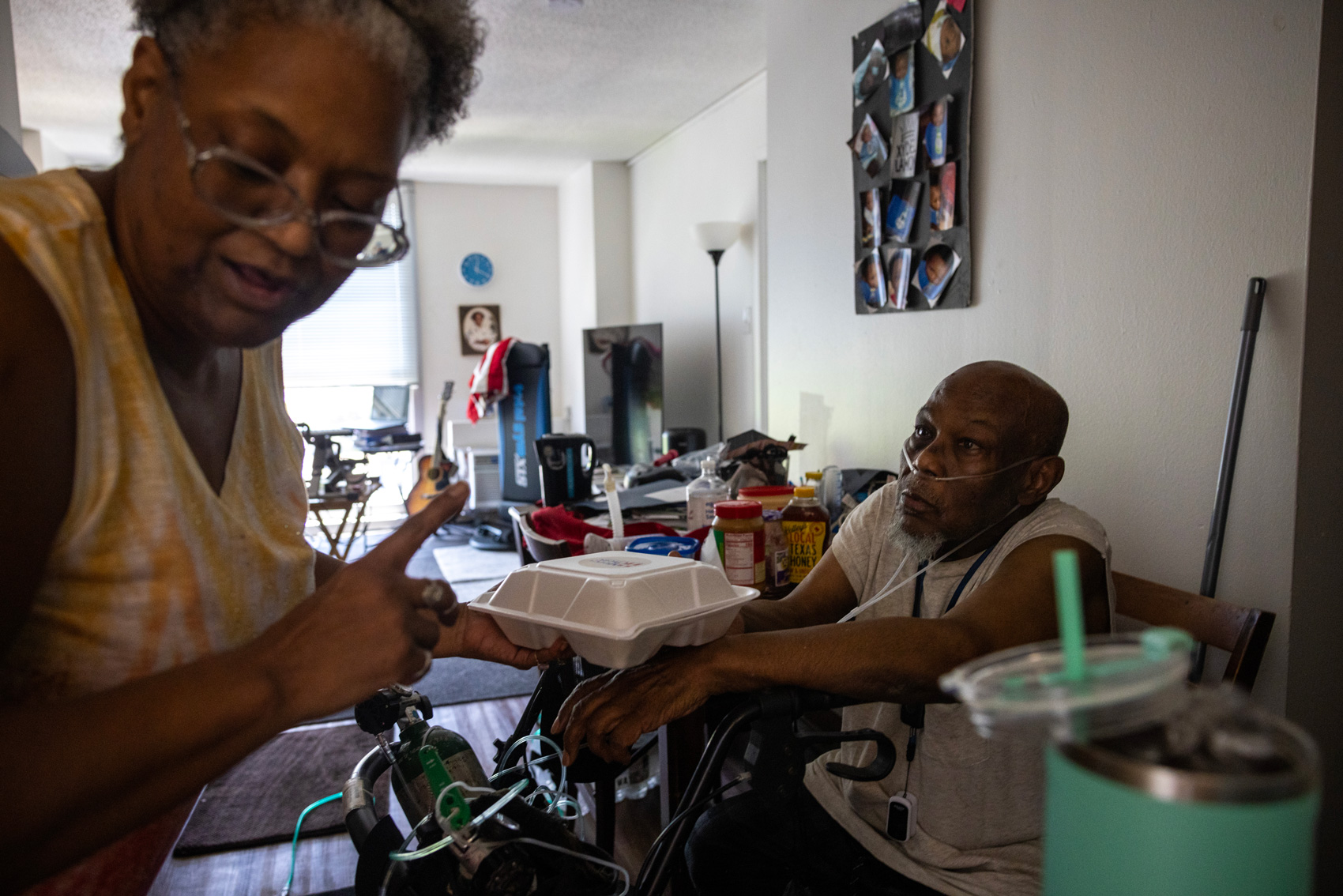 Stacey Pakosta, 62, at left, delivers food to her friend William Griggs, 74, who is on oxygen at Heights House, Sunday, May 19, 2024, in Houston.