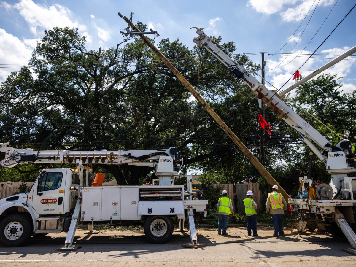 A crew works on installing a new utility pole on Durham Drive, Sunday, May 19, 2024, in Houston after a powerful windstorm swept through the city.