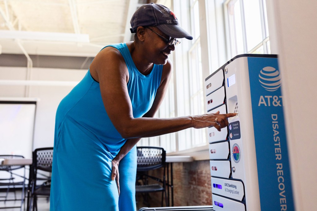 Nowell Degree retrieves her cellphone and a portable charger from the AT&T charging stations at the cooling center inside the Leonel Castillo Community Center on Sunday, May 19, 2024, in Houston.
