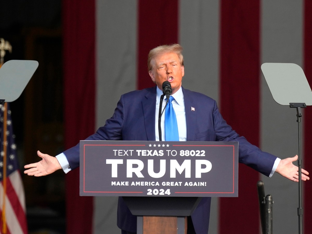 Former President Donald Trump speaks to a crown from behind a podium.