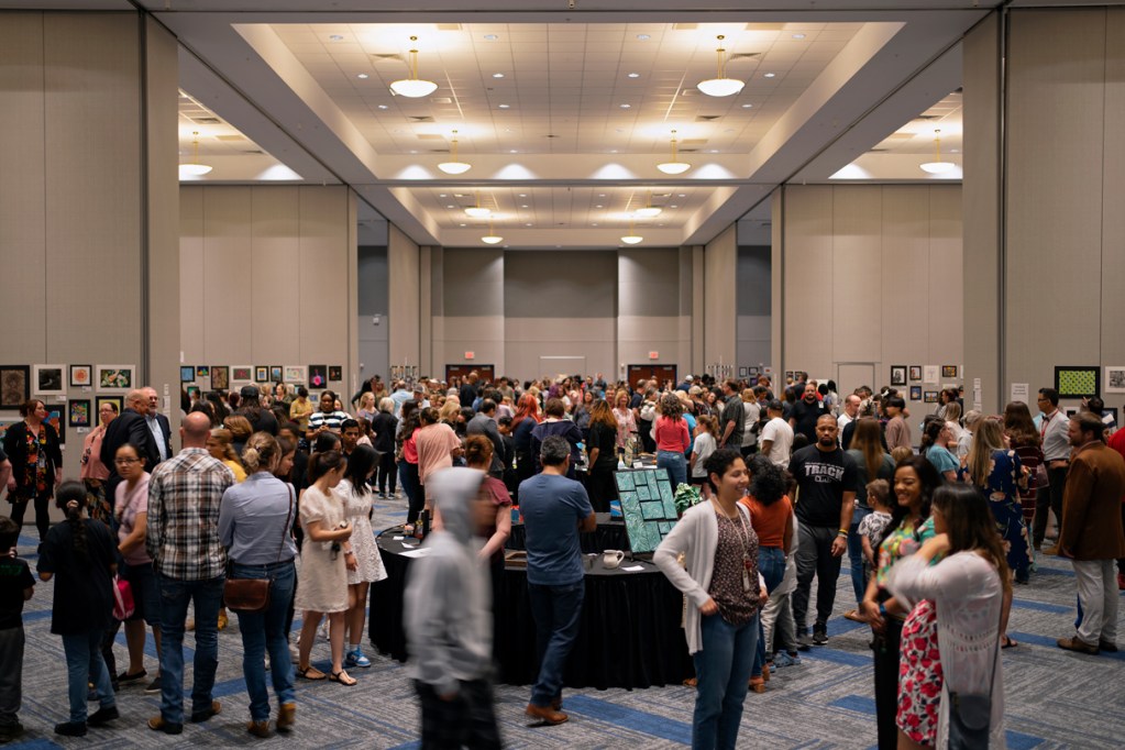 People attend a student art exhibit in Cypress