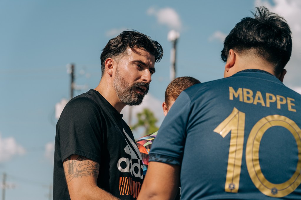 On the left, Juan Vega, a Houstonian who had to quit his job with the Dynamo because his status changed through the DACA program, speaks to a player participating in Cascaritas, a gathering of friends and communities to play soccer, on Saturday, Sept. 30, 2023, in Houston.