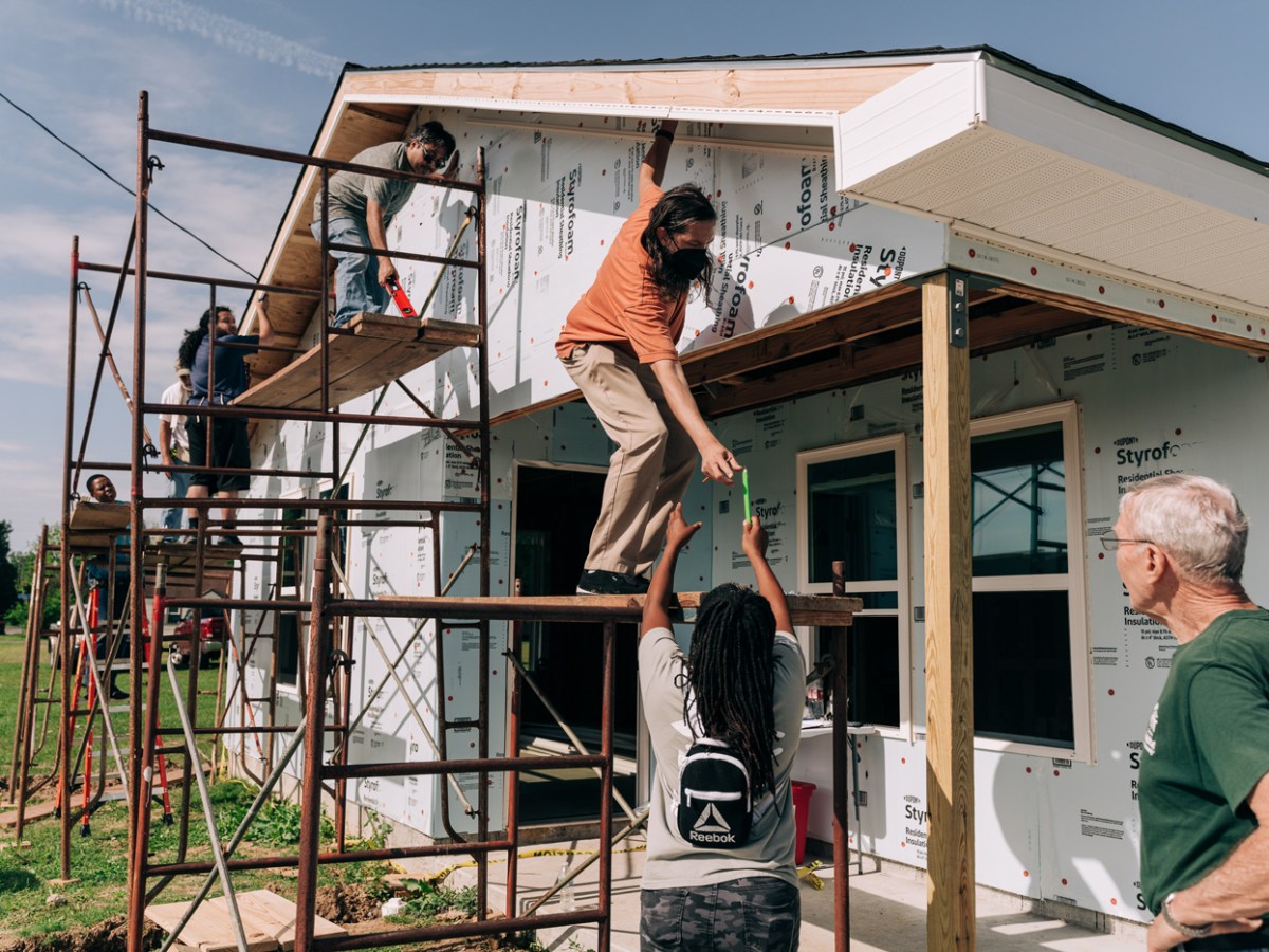 A group of people works on a house construction