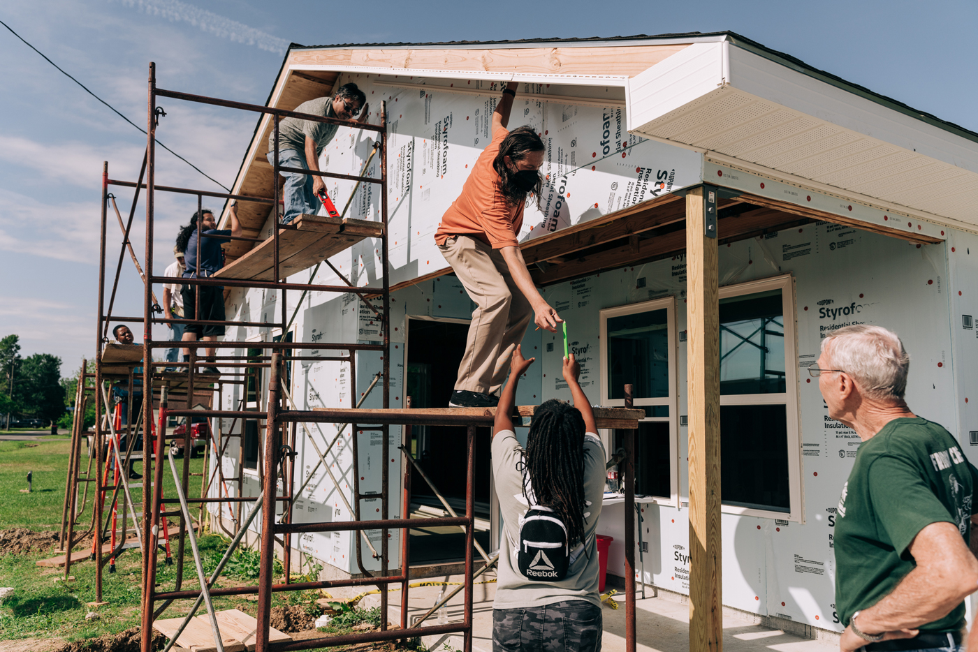 A group of people works on a house construction