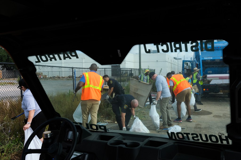 Volunteers and community leaders help clean up a section of the Bissonnet "Track."