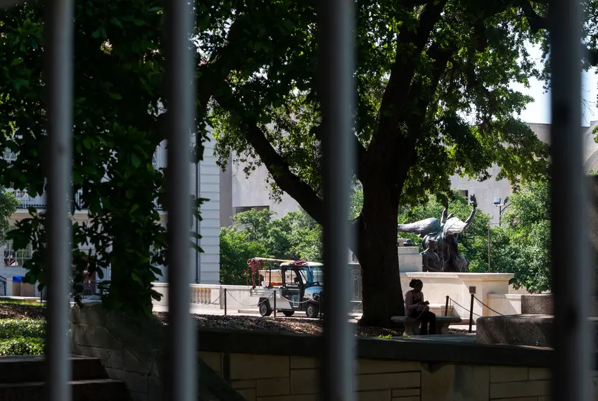 A student sits by the Littlefield Fountain at the University of Texas.