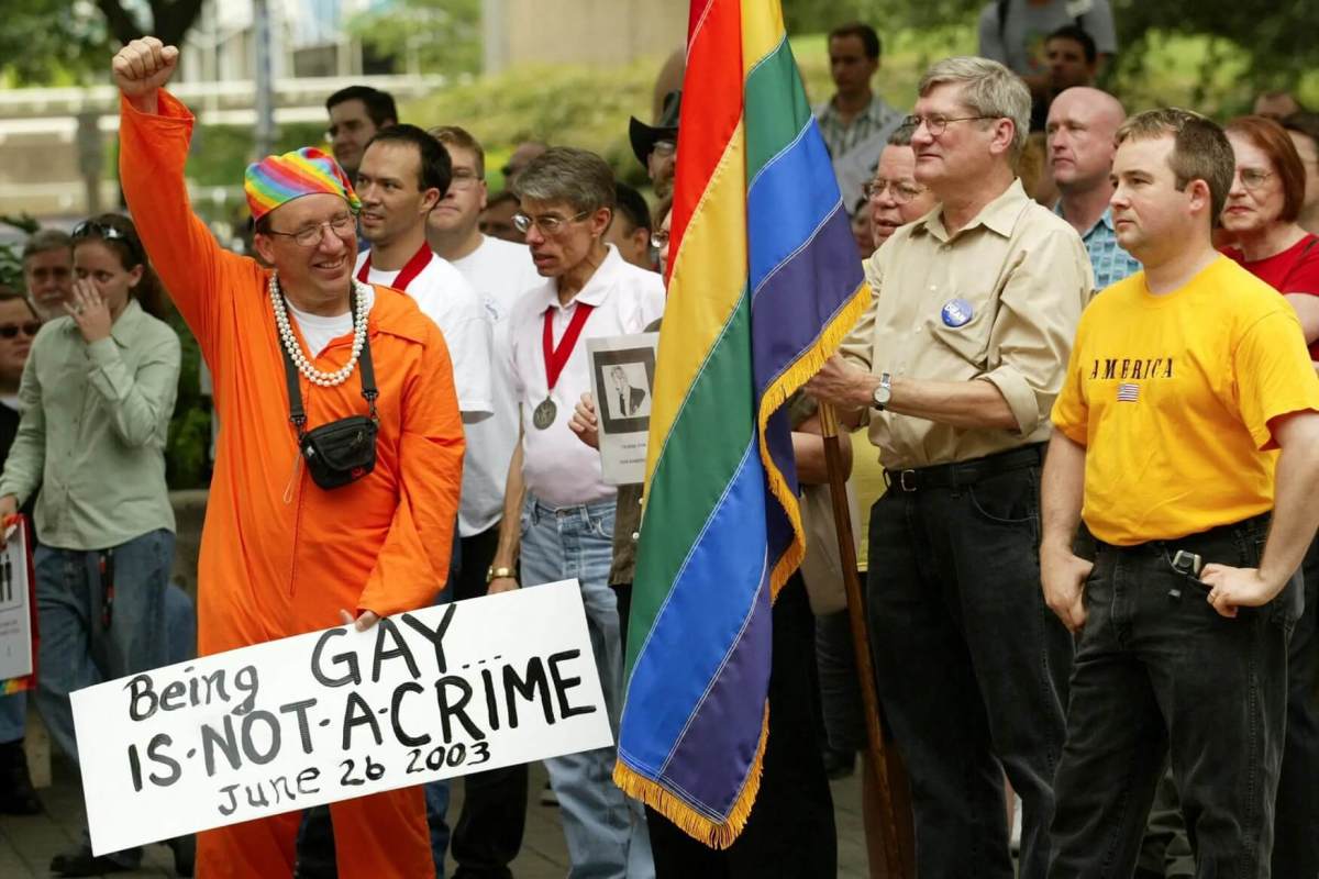 People with signs and flags celebrate the landmark U.S. Supreme Court decision in the Lawrence v. Texas case outside City Hall in Houston.