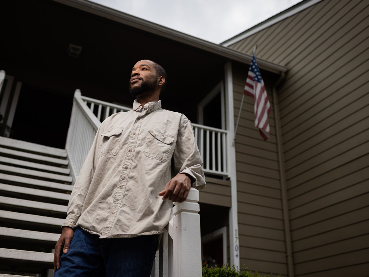 Chris Murray stands behind a stairway with an American flag behind him