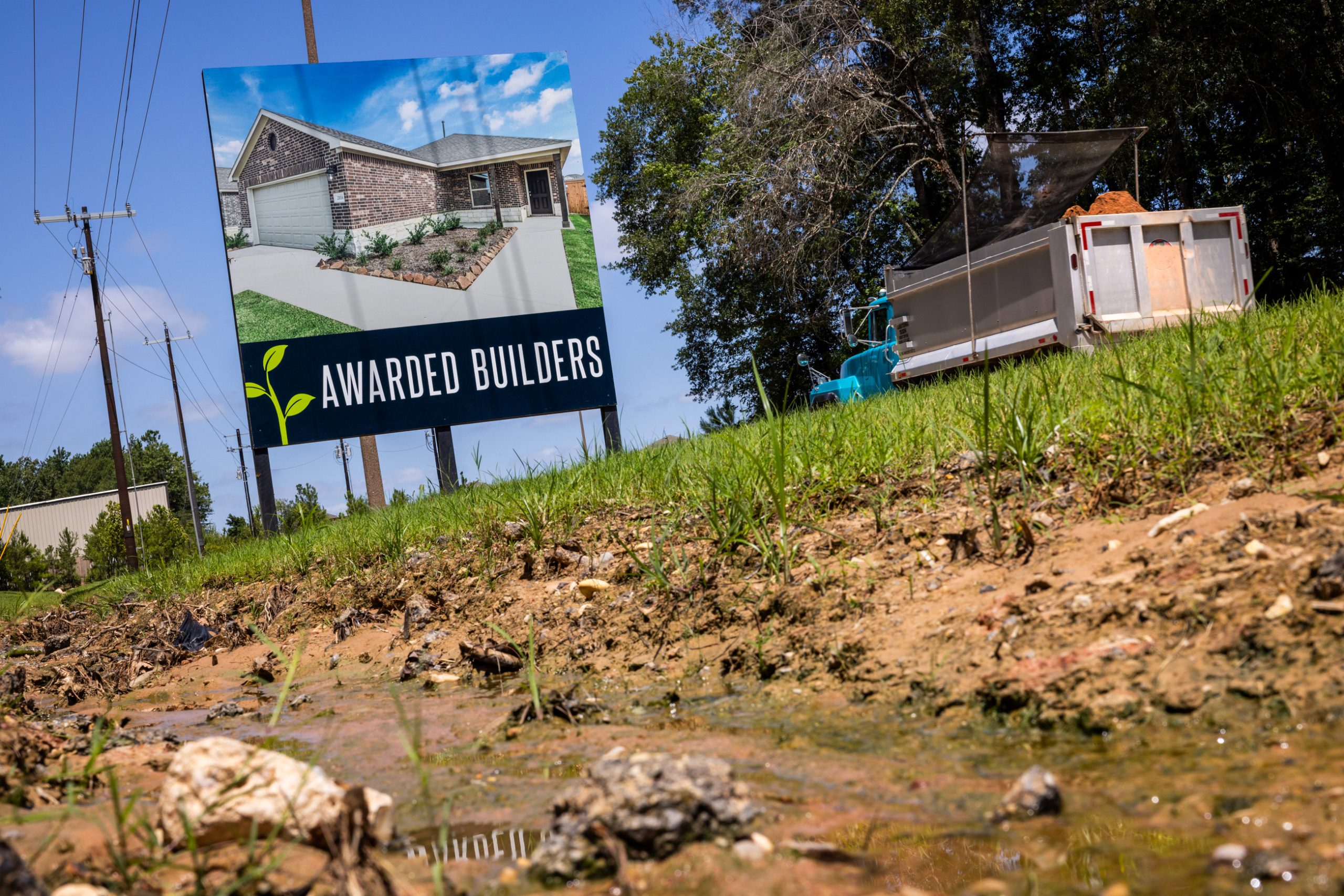 A truck carrying dirt drives towards the construction sites at the Chapel Run housing community