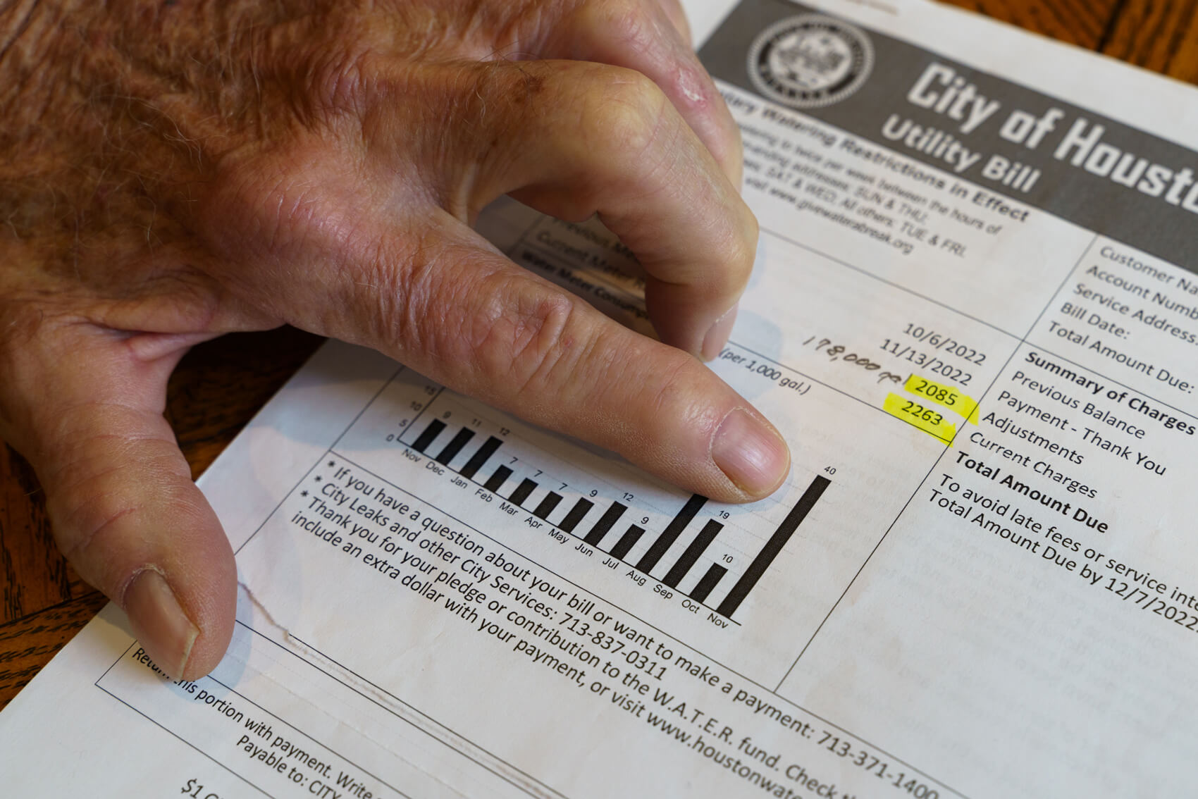 J.C Davenport points at his water bill showing a sudden spike in his water consumption. (Joseph Bui for Houston Landing)