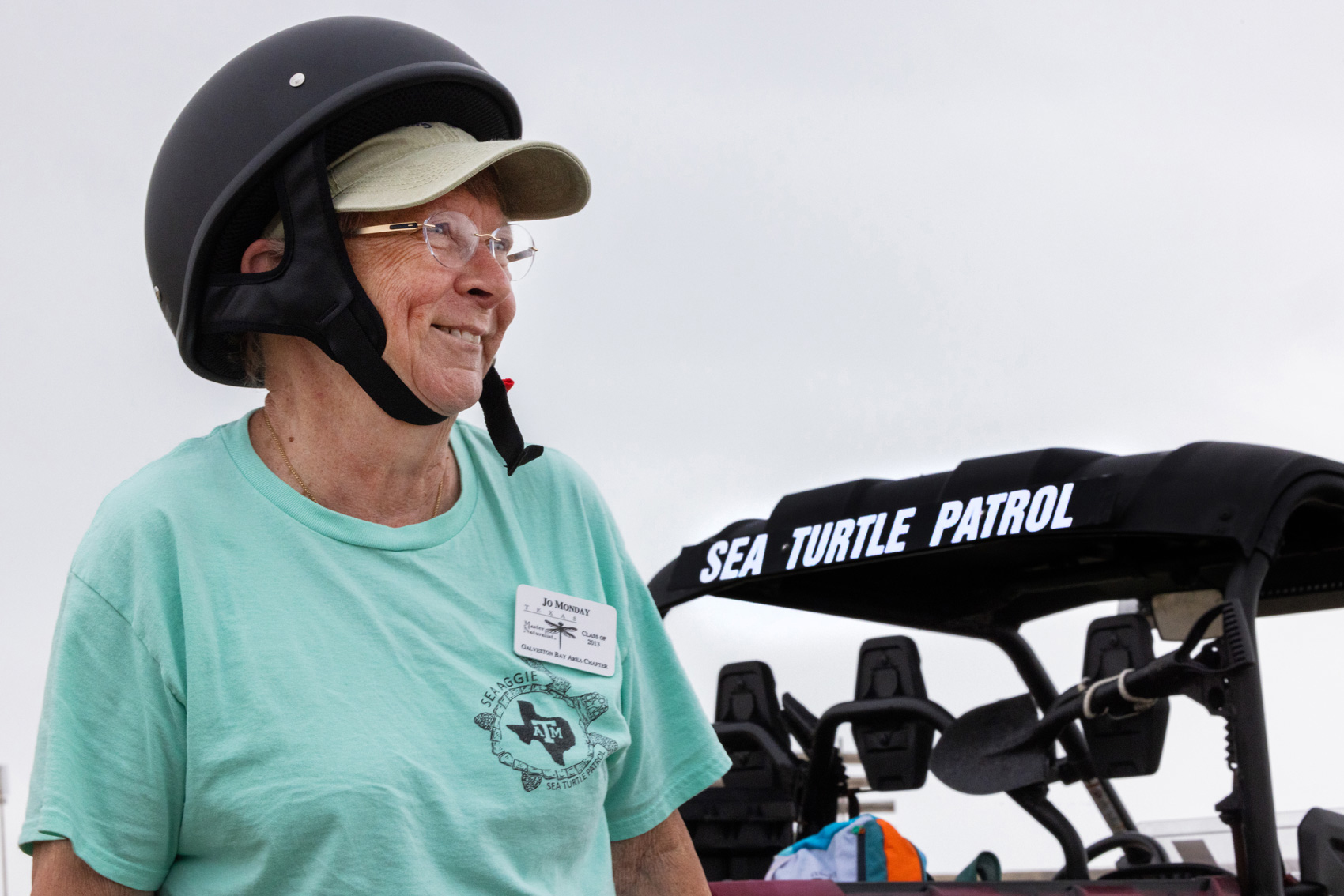 Jo Monday, 76, a master naturalist and Gulf Center for Sea Turtle Research volunteer, takes a look at Galveston Beach visitors while patrolling the area on the lookout for any sea turtles or sea turtle tracks that could lead her to a nesting site