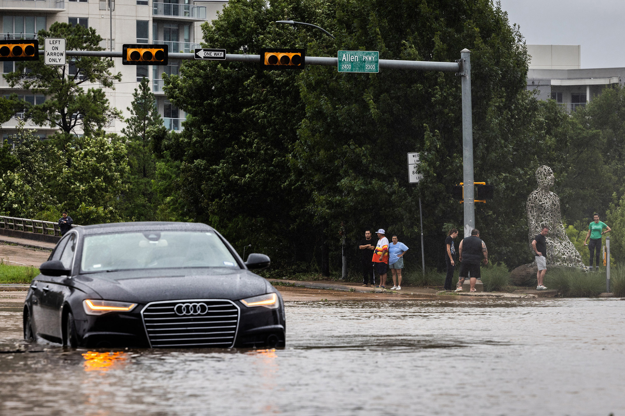 A sedan is submerged within flood waters at the intersection of Allen Parkway and Montrose Blvd., Monday, July 8, 2024, in Houston. 